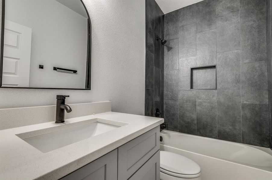 Full bathroom with vanity, toilet, and tiled shower / bath