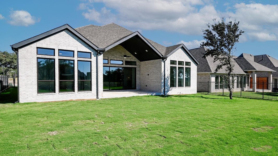 Back of property featuring ceiling fan, a patio area, brick siding, and roof with shingles Back of property featuring ceiling fan, a patio area, brick siding, and roof with shingles