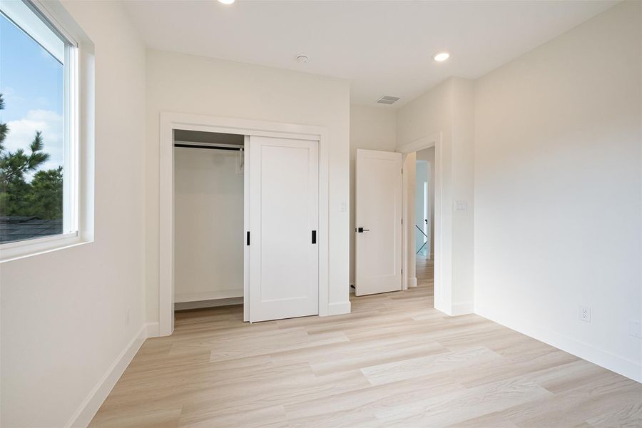 Unfurnished bedroom featuring light wood finished floors and a closet