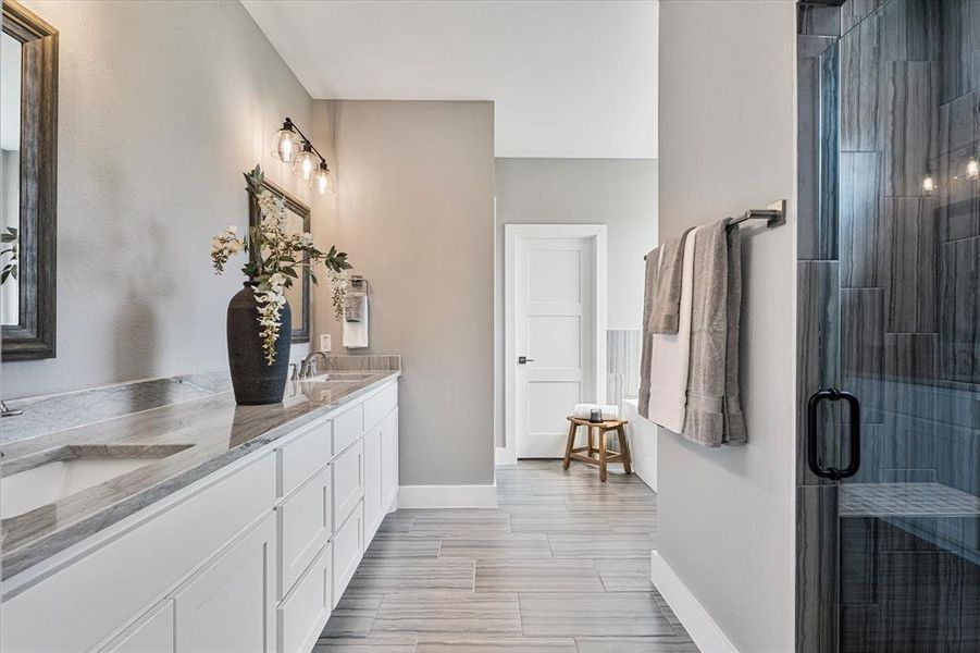 Bathroom with tile patterned floors, a shower with door, and vanity