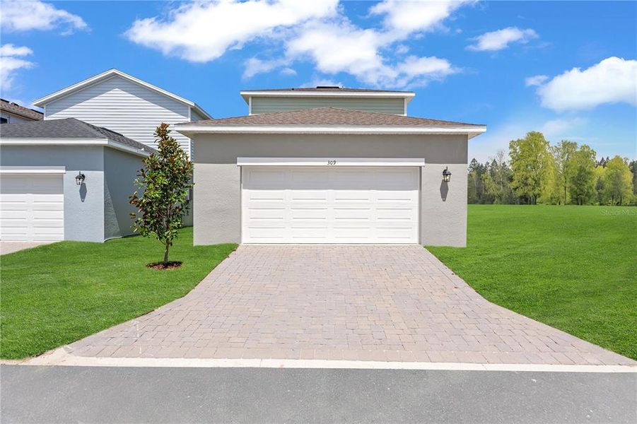 Front exterior of a new home in Spring Walk at the Junction, Debary, FL, highlighting curb appeal (Image 2). Front exterior of a new home in Spring Walk at the Junction, Debary, FL, highlighting curb appeal (Image 2).