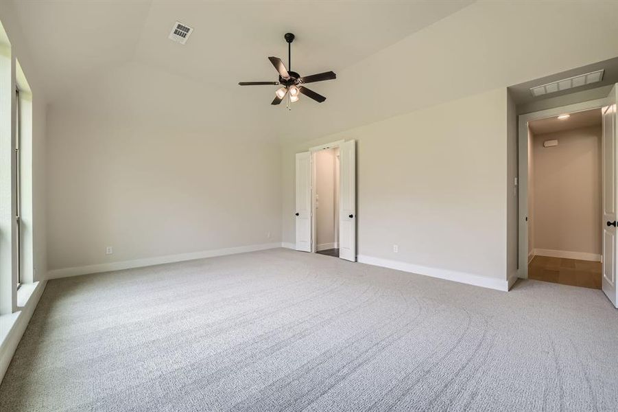 Unfurnished room with lofted ceiling, light carpet, and ceiling fan Unfurnished room with lofted ceiling, light carpet, and ceiling fan