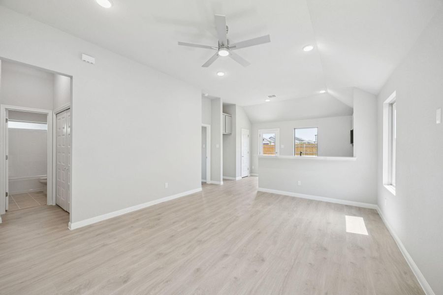 Unfurnished living room with ceiling fan, light wood-style flooring, recessed lighting, and lofted ceiling