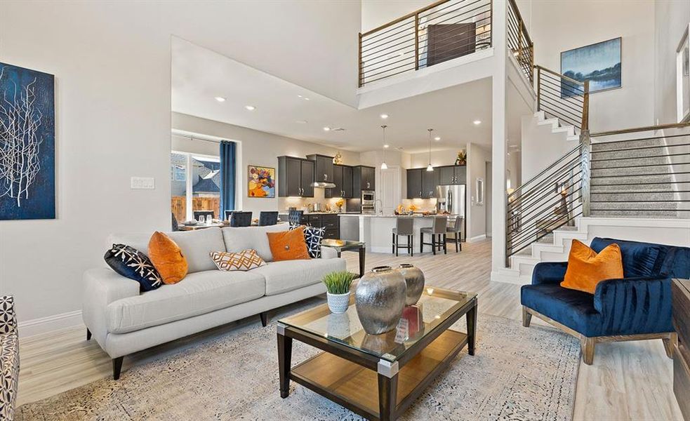 Living room featuring a high ceiling and light hardwood / wood-style flooring