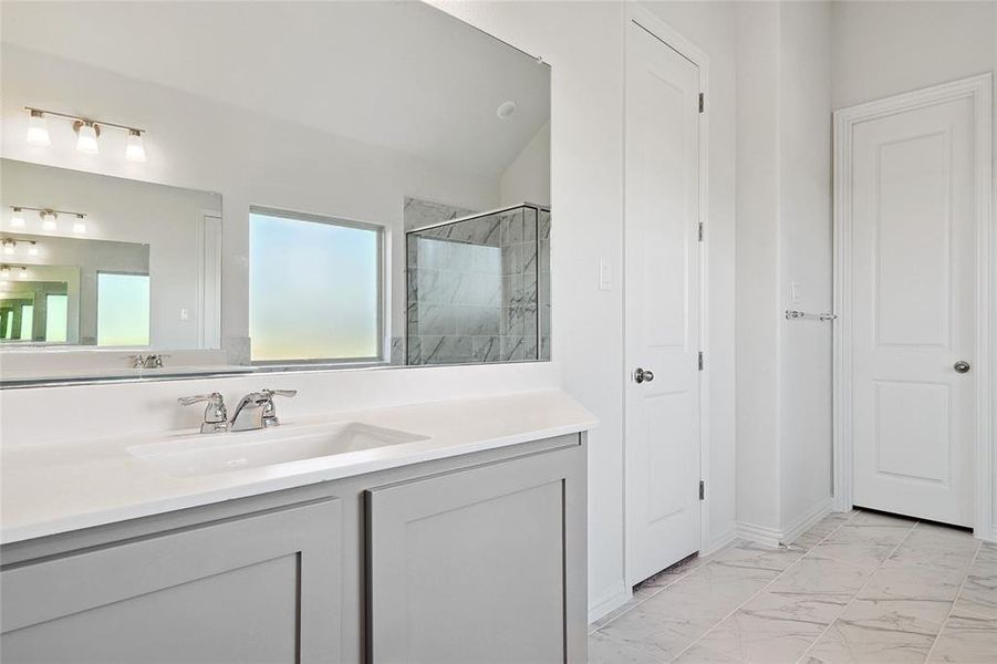 Bathroom featuring vanity, vaulted ceiling, and a shower with shower door