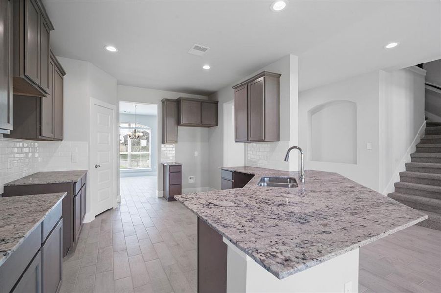 This kitchen is by far any chef’s dream! This spacious kitchen features high ceilings, stained wood cabinets, granite countertops, SS appliances, modern tile backsplash, recessed lighting, extended counter space, granite kitchen island with space for breakfast bar and a walk-in pantry all overlooking your huge family room.