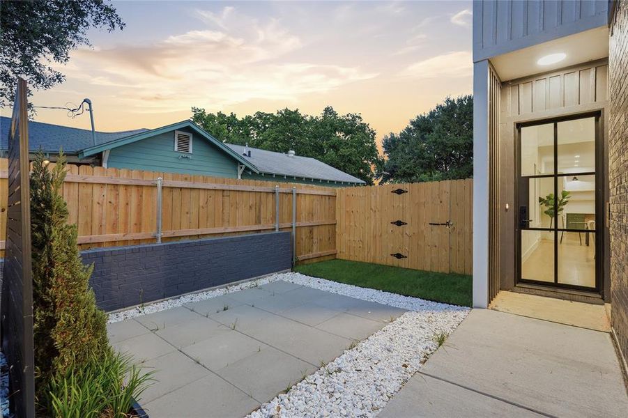 Modern entry door with black grid design, featuring a concrete pathway and white decorative gravel Modern entry door with black grid design, featuring a concrete pathway and white decorative gravel