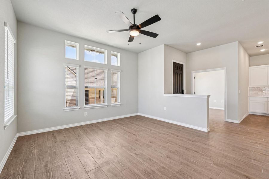 Empty room featuring light wood-style flooring, plenty of natural light, a ceiling fan, recessed lighting, and baseboards Empty room featuring light wood-style flooring, plenty of natural light, a ceiling fan, recessed lighting, and baseboards