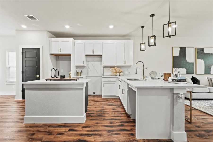 Kitchen featuring white cabinetry, tasteful backsplash, decorative light fixtures, and recessed lighting Kitchen featuring white cabinetry, tasteful backsplash, decorative light fixtures, and recessed lighting