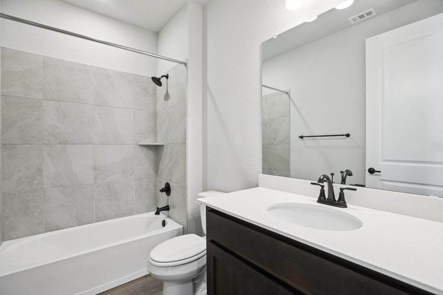 Bathroom with shower / tub combination, vanity, and dark wood finished floors Bathroom with shower / tub combination, vanity, and dark wood finished floors