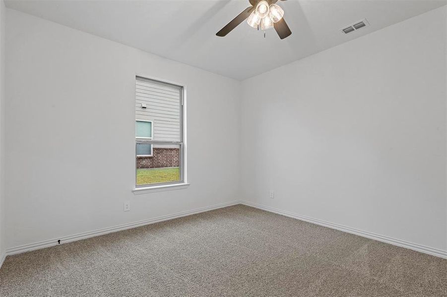 Carpeted spare room featuring ceiling fan