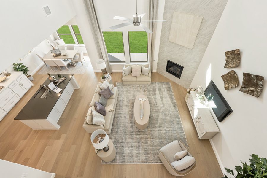 Open-concept living area with high ceilings, fireplace, and kitchen island viewed from above