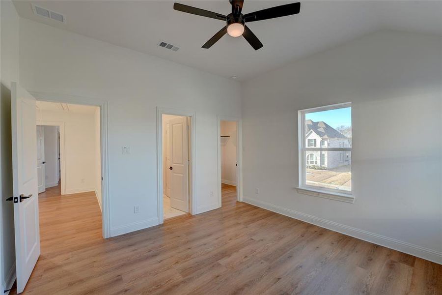 Bedroom with vinyl flooring, baseboards, and visible vents