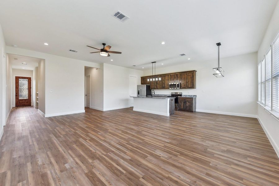 Unfurnished living room with visible vents, recessed lighting, ceiling fan, and wood finished floors Unfurnished living room with visible vents, recessed lighting, ceiling fan, and wood finished floors