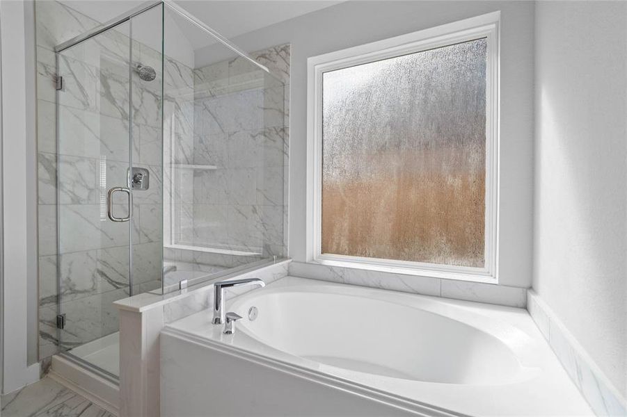 Additional view of the primary bathroom features a dark framed walk-in shower with tile surround, separate garden tub for soaking after a long day with custom tile detailing.