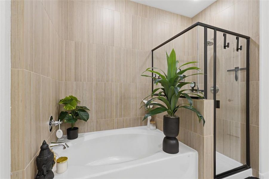 Soaking tub with chrome fixtures, surrounded by vertically oriented wood-finish wall tile Soaking tub with chrome fixtures, surrounded by vertically oriented wood-finish wall tile