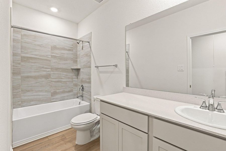 Clean lines and stone counters highlight this beautifully tiled contemporary bath.