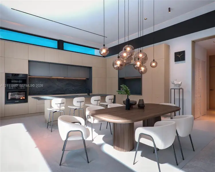 Contemporary kitchen featuring flat-panel cabinetry, a stone-surfaced island with integrated seating, recessed dark-toned backsplashes, built-in double wall ovens, and a multi-pendant light fixture Contemporary kitchen featuring flat-panel cabinetry, a stone-surfaced island with integrated seating, recessed dark-toned backsplashes, built-in double wall ovens, and a multi-pendant light fixture