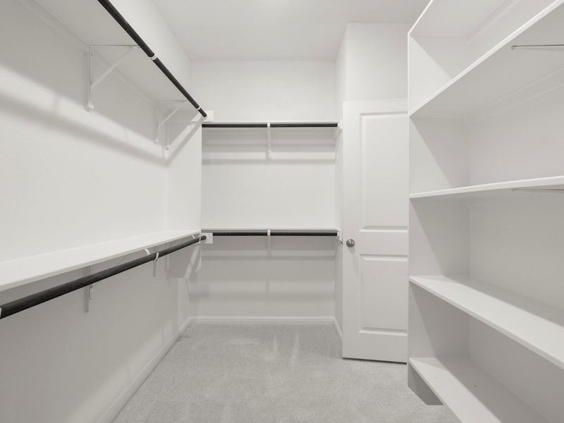 Organized and ready for personal touches, this walk-in closet boasts ample shelving and hanging space.