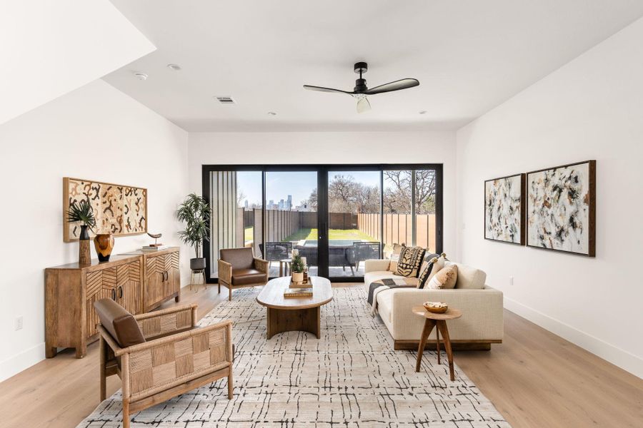 Living area featuring light wood-style flooring and a ceiling fan