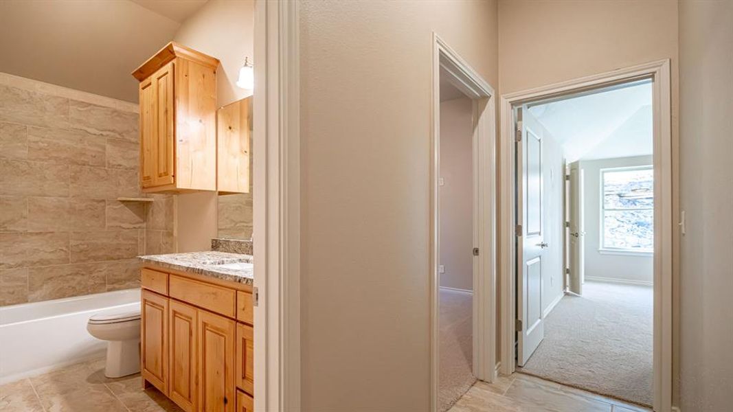 Full bath featuring vanity, bathtub / shower combination, and light colored carpet