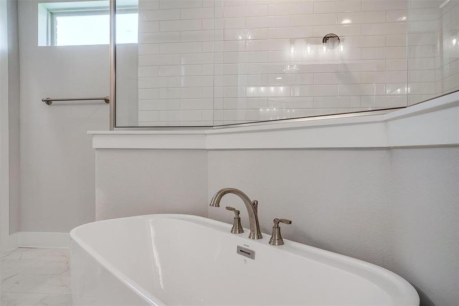 Bathroom featuring a tub to relax in and tile patterned floors