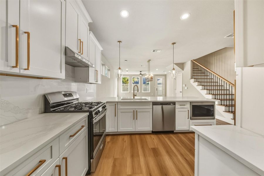 Experience the seamless flow from the pantry and garage hallway into this bright, modern kitchen, featuring sleek cabinetry, high-end appliances, and a spacious island perfect for entertaining. Experience the seamless flow from the pantry and garage hallway into this bright, modern kitchen, featuring sleek cabinetry, high-end appliances, and a spacious island perfect for entertaining.