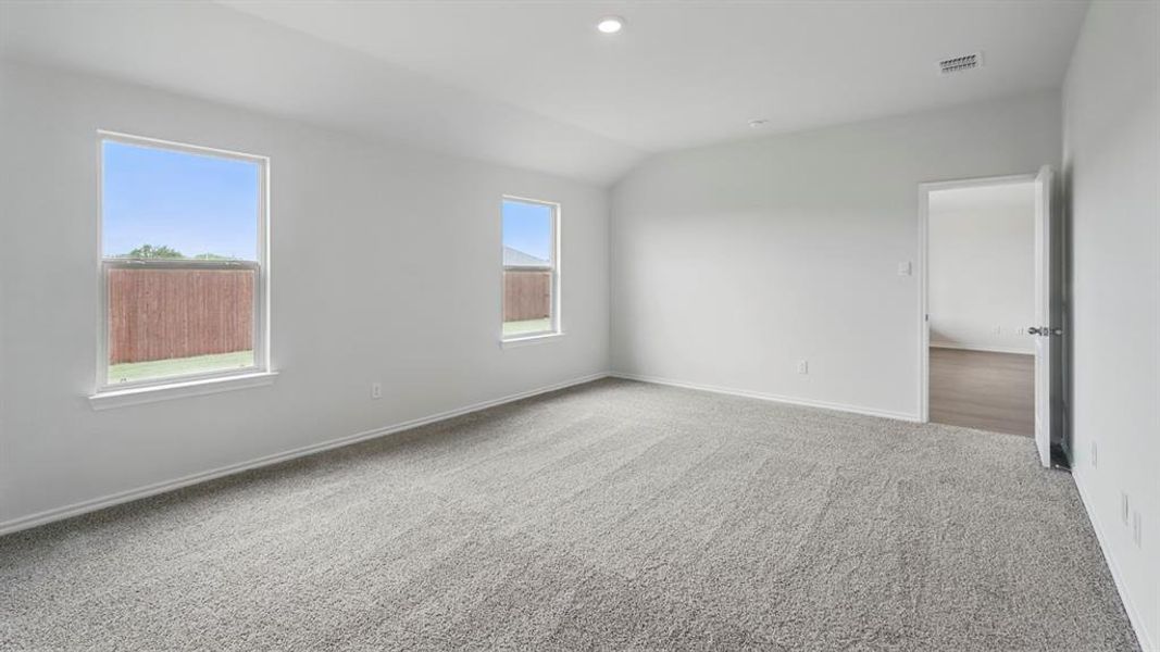 Spacious room featuring neutral carpeting, white walls, and two windows providing natural illumination