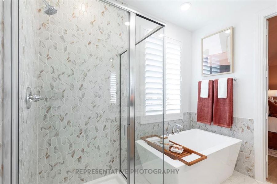 Bathroom featuring a shower stall, a freestanding tub, tile walls, and a wainscoted wall