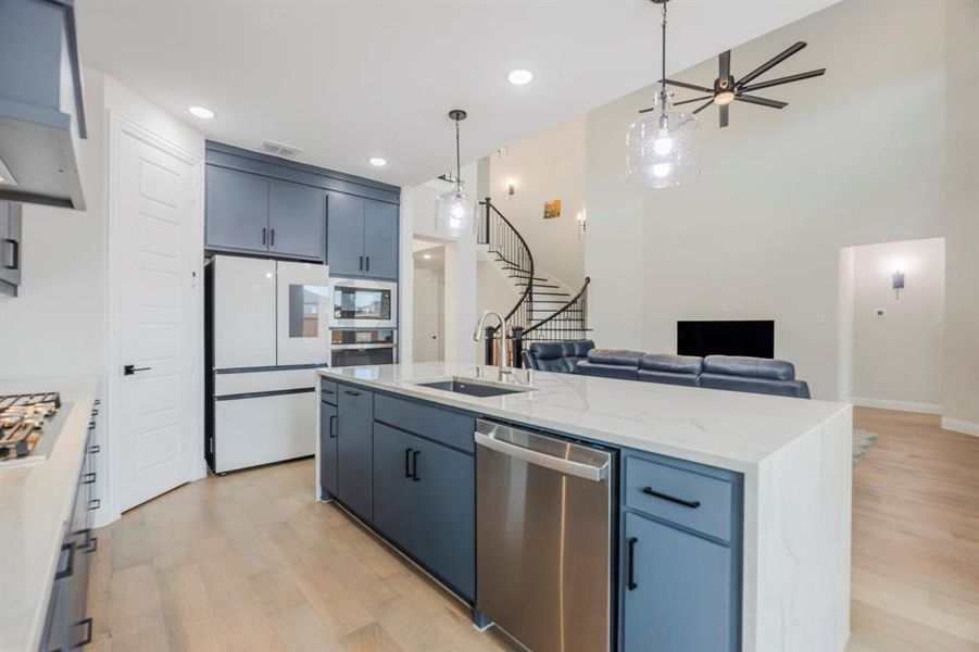 Kitchen with visible vents, a sink, open floor plan, light wood-style floors, and appliances with stainless steel finishes