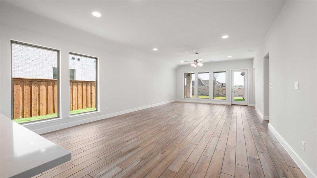 Unfurnished living room with ceiling fan and light wood-type flooring