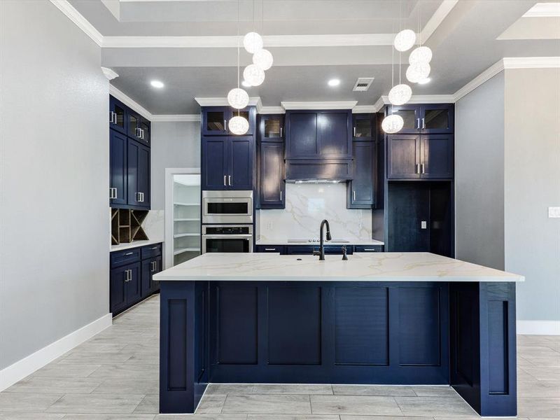 Kitchen featuring decorative backsplash, pendant lighting, wood tiled floors, light stone countertops, and crown molding Kitchen featuring decorative backsplash, pendant lighting, wood tiled floors, light stone countertops, and crown molding