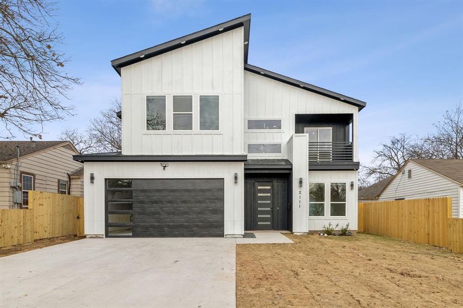 View of front of property with a garage and a balcony