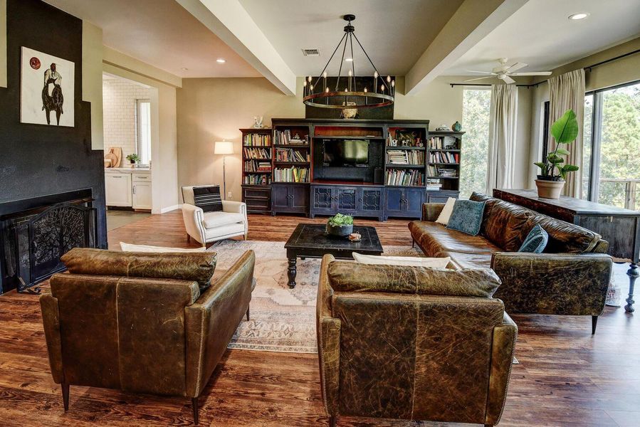 Living area featuring beam ceiling, wood finished floors, a fireplace, recessed lighting, and ceiling fan Living area featuring beam ceiling, wood finished floors, a fireplace, recessed lighting, and ceiling fan