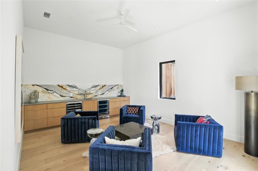 Bonus wet bar Lounge w/ wine fridge, light wood finished floors, and a ceiling fan Bonus wet bar Lounge w/ wine fridge, light wood finished floors, and a ceiling fan