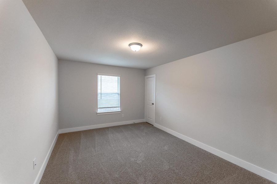 Spare room featuring light carpet and a textured ceiling