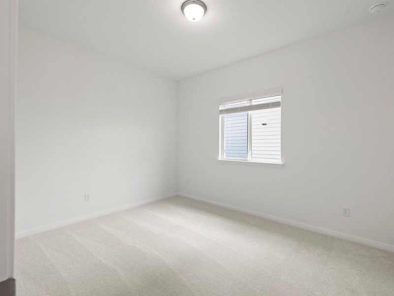 An airy bedroom with fresh carpeting, ready for personalization.