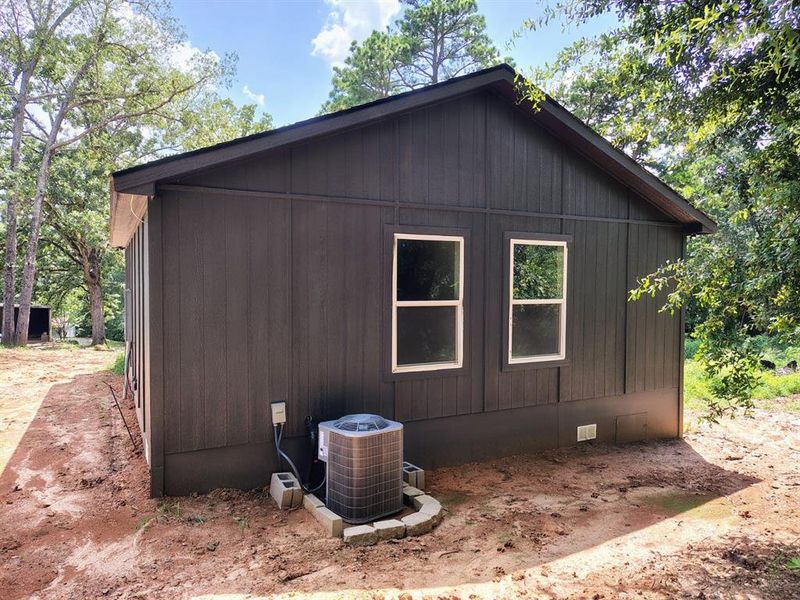 View of side of property with a cooling unit and crawl space