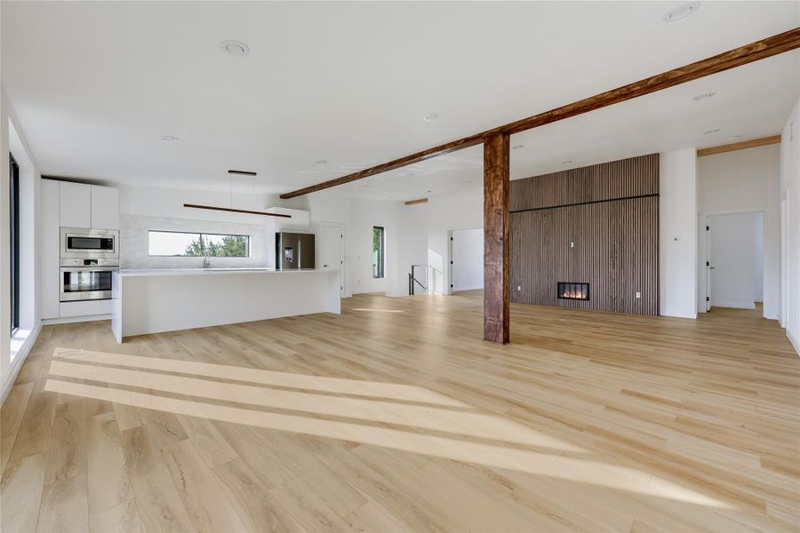 Unfurnished living room with light wood-type flooring and a fireplace Unfurnished living room with light wood-type flooring and a fireplace