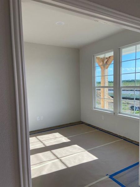 Bright interior room featuring a recessed ceiling light, two large windows, white trim, and light-toned wall paint