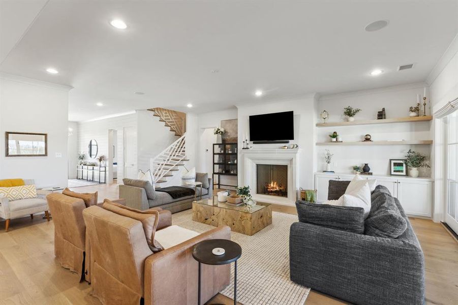 Living room featuring visible vents, light wood-style flooring, stairway, crown molding, and recessed lighting Living room featuring visible vents, light wood-style flooring, stairway, crown molding, and recessed lighting
