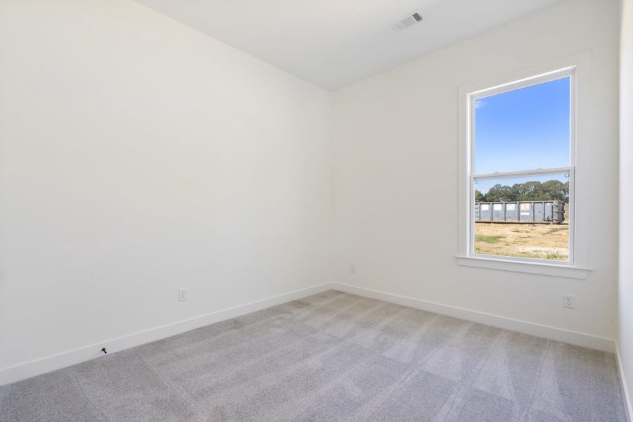 Neutral-toned interior room featuring wall-to-wall carpeting and a single-hung window with exterior landscape exposure Neutral-toned interior room featuring wall-to-wall carpeting and a single-hung window with exterior landscape exposure