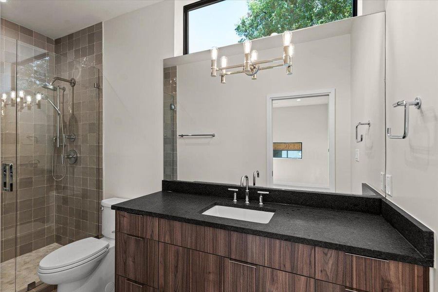 A sleek modern bathroom features a spacious vanity with an undermount sink and a glass-enclosed shower. A sleek modern bathroom features a spacious vanity with an undermount sink and a glass-enclosed shower.