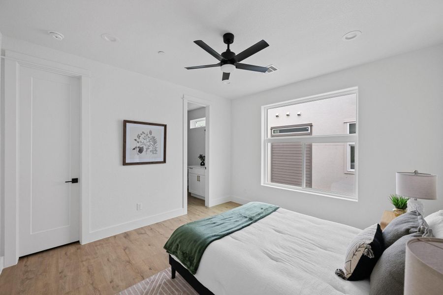 Bedroom featuring light wood-finish flooring, a contemporary ceiling fan with integrated lighting, and recessed ceiling lights