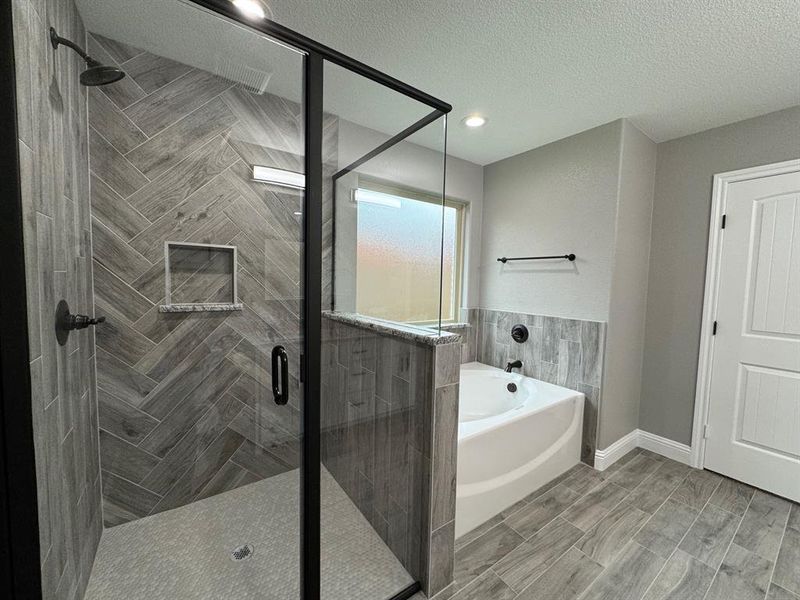 Bathroom with a textured ceiling and plus walk in shower