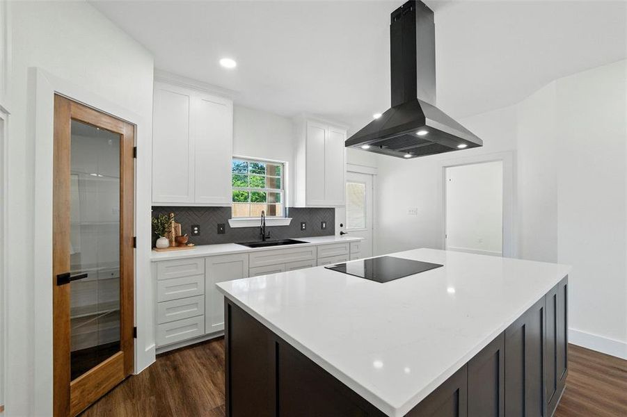 Kitchen with island exhaust hood, black electric cooktop, dark wood finished floors, a center island, and recessed lighting