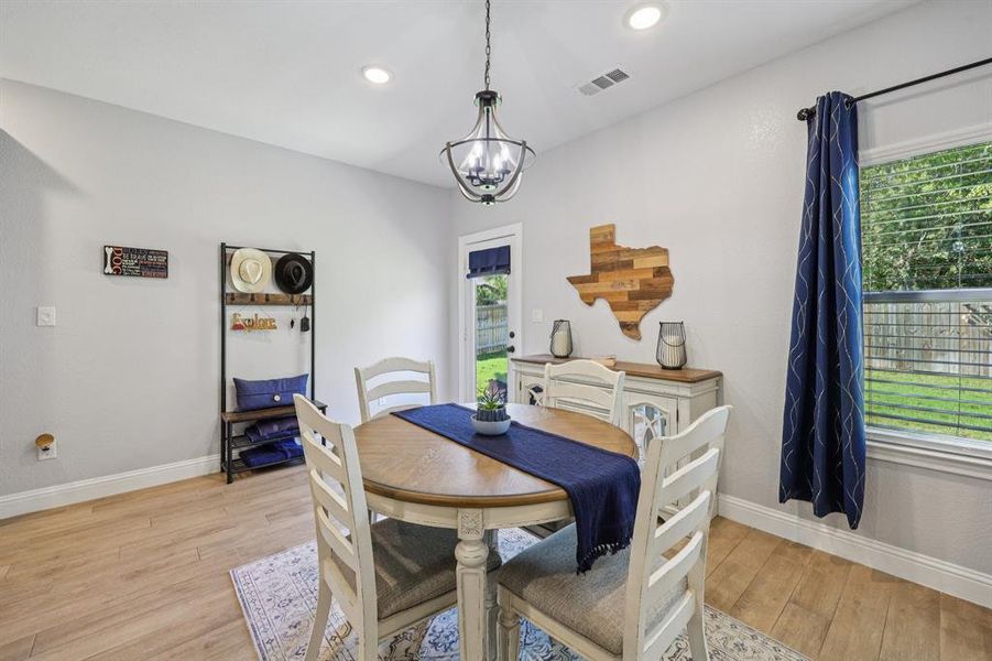 Dining space with light wood finished floors, recessed lighting, and a chandelier Dining space with light wood finished floors, recessed lighting, and a chandelier