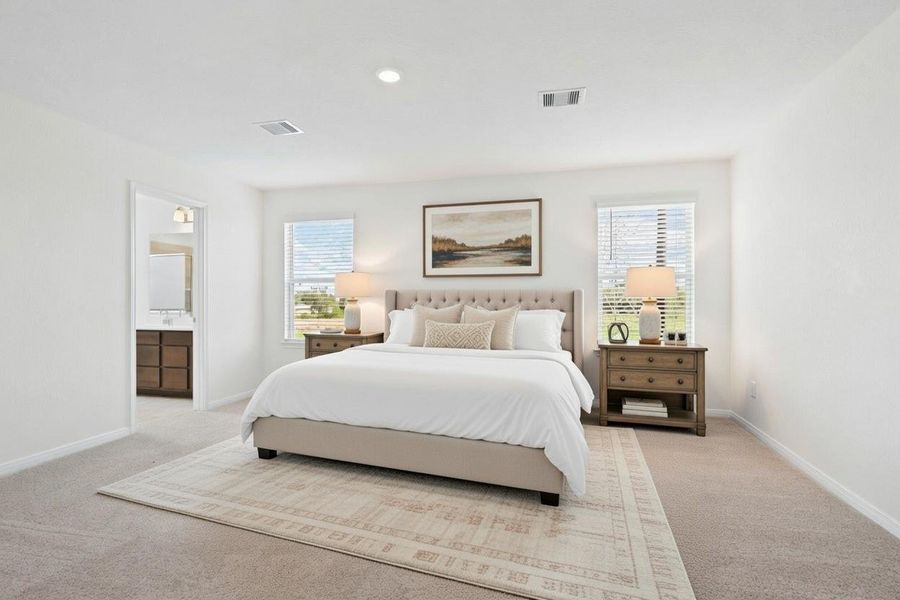 Relax and unwind after a long day in this impressive primary suite! This generously sized room offers plush carpeting, warm-toned paint, high ceilings with recessed lighting, and large windows with privacy blinds for added comfort and tranquility.