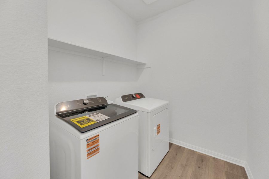Washroom featuring light wood-style floors and washing machine and dryer Washroom featuring light wood-style floors and washing machine and dryer