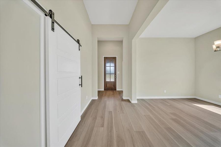 Entrance foyer with a barn door and light wood-type flooring Entrance foyer with a barn door and light wood-type flooring